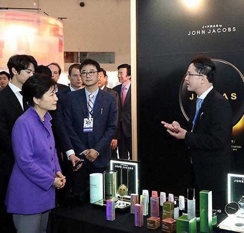 박근혜 대통령이 지난 6월 'KCON 2016 프랑스' 행사에서 존제이콥스 부스를 방문해 관계자로부터 설명을 듣고 있는 모습. 존제이콥스에서 생산한 화장품(제이프라스)는 지난 2월 청와대 설 선물로 선정돼 납품됐다. 